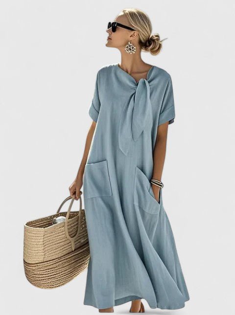 Elegant summer dress featuring a chic neck tie and functional pockets, perfect for versatile styling in warm weather. 0